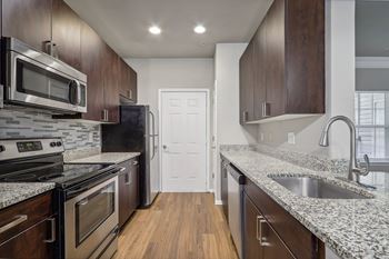 a kitchen with granite counter tops and stainless steel appliances